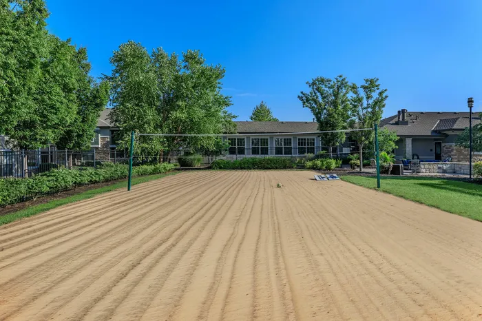 Outdoor sand volleyball court surrounded by greenery at Corbin Crossing apartments in Overland Park KS