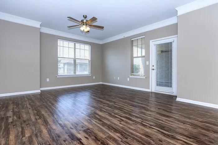 Amherst floor plan spacious living room with wood flooring and large windows at Corbin Crossing Overland Park KS