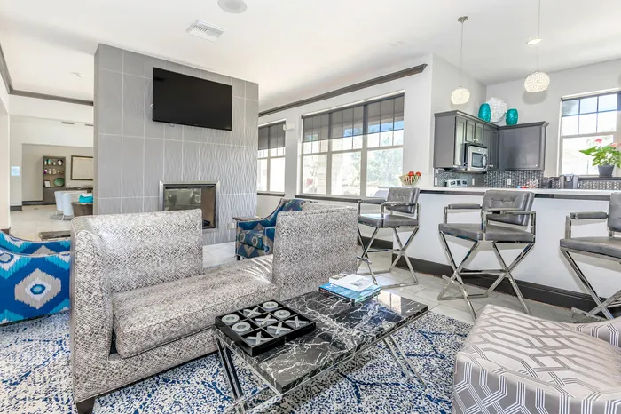 Clubhouse lounge with fireplace and open kitchen at Corbin Crossing apartment community in Overland Park KS