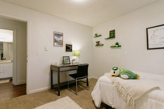 Furnished private bedroom with modern desk and cozy decor at Stadium Park in Eugene OR