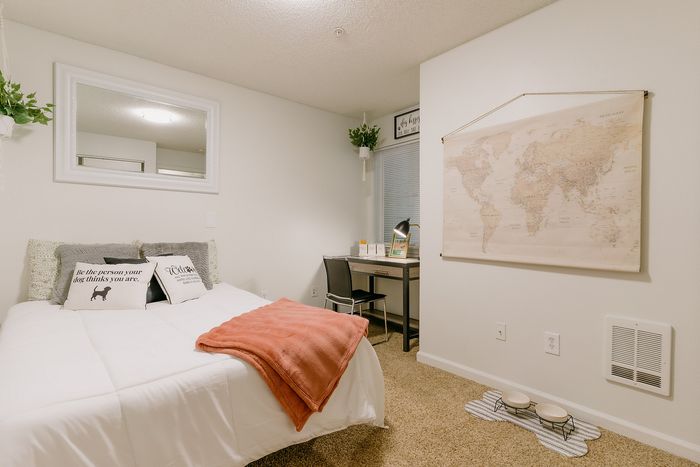 Furnished model bedroom with study nook and world map decor at Stadium Park in Eugene OR