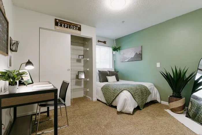 Furnished model bedroom with cozy earth tones at Stadium Park student apartments in Eugene OR