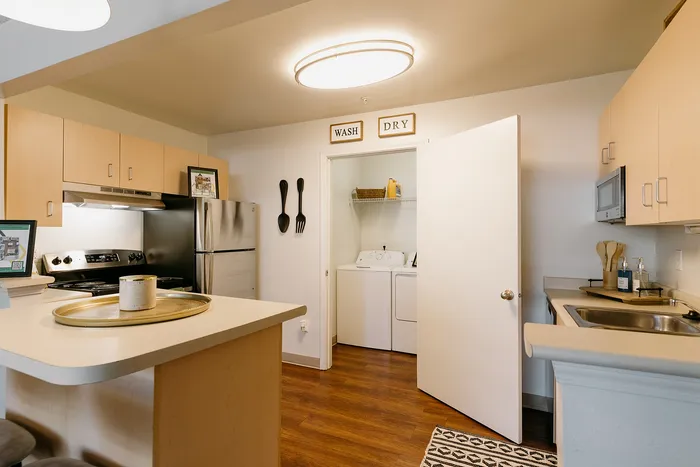 Modern kitchen with stainless appliances and in-unit washer dryer at Stadium Park in Eugene OR