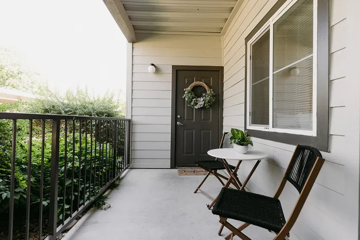 Private patio with wicker furniture at Stadium Park student apartments in Eugene OR