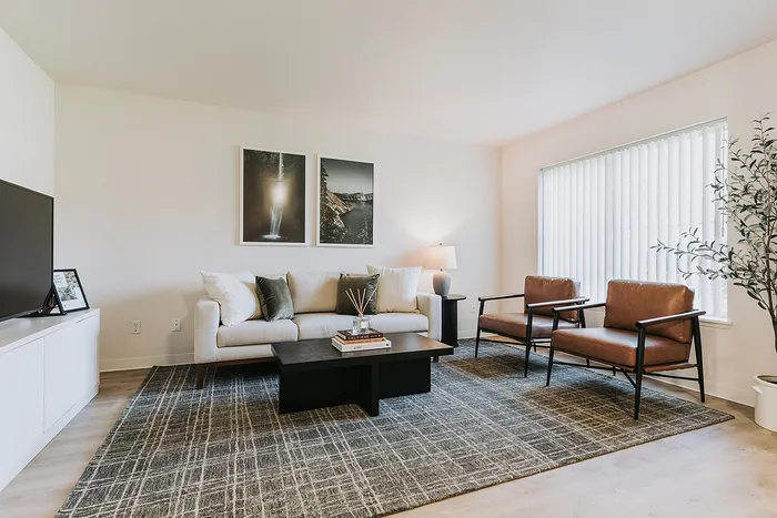 Inviting living room with a stylish sofa, modern artwork, and natural light streaming through large windows.