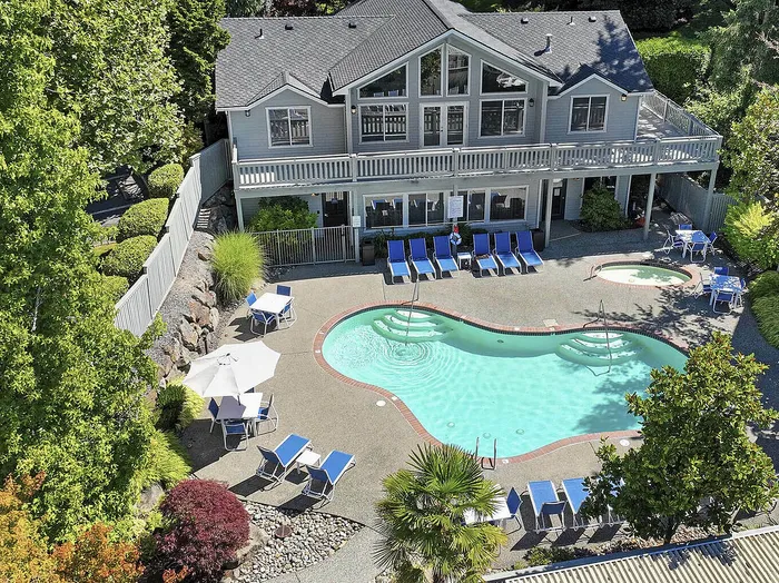 Canyon Springs apartment complex aerial view of heated outdoor pool surrounded by lush greenery and lounge chairs in Lynnwood WA