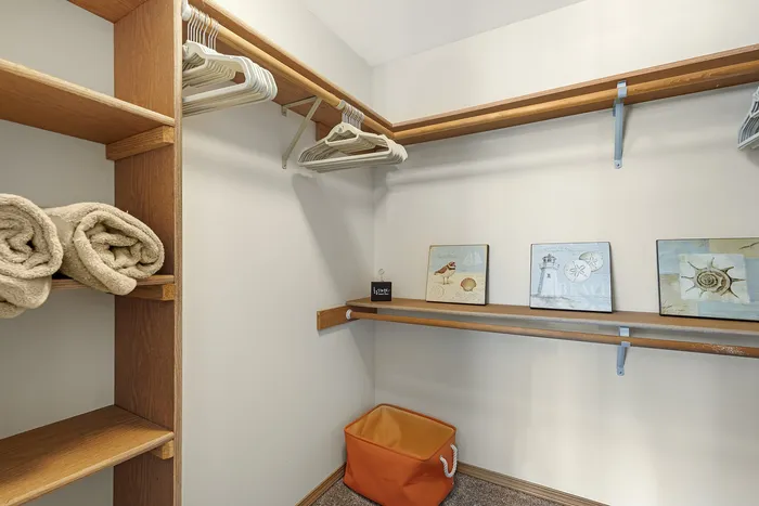 Canyon Springs spacious apartment walk-in closet with built-in wooden shelving and ample storage in Lynnwood Washington