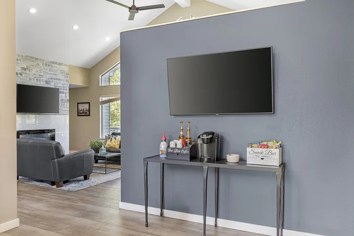 Canyon Springs clubhouse fireside lounge with wall-mounted TV and cozy coffee station for residents in Lynnwood WA