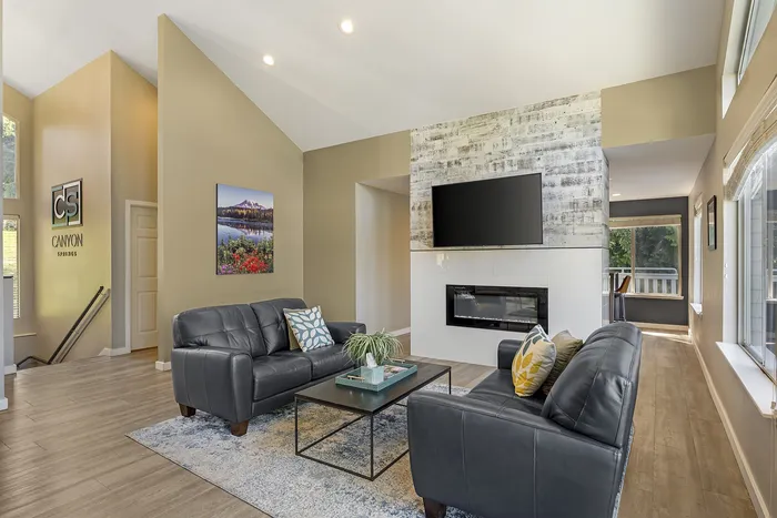 Canyon Springs clubhouse fireside lounge with leather sofas wood accent wall and cozy fireplace in Lynnwood WA