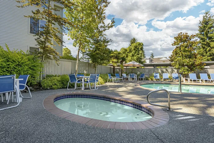 Canyon Springs resort-style pool deck with relaxing lounge chairs and vibrant greenery in Lynnwood WA