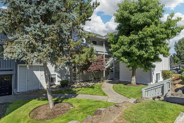Canyon Springs apartment exterior with manicured landscaping vibrant trees and welcoming pathway in Lynnwood Washington
