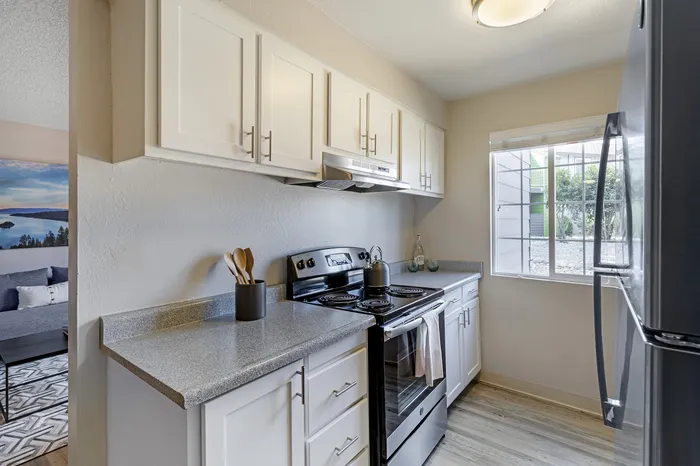 The Phoenix Reno model kitchen with white cabinets, stainless steel appliances, and natural light in Reno NV