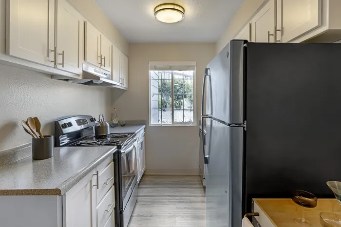 The Phoenix Reno bright modern kitchen with stainless steel appliances, ample cabinetry, and sunlit window in Reno NV