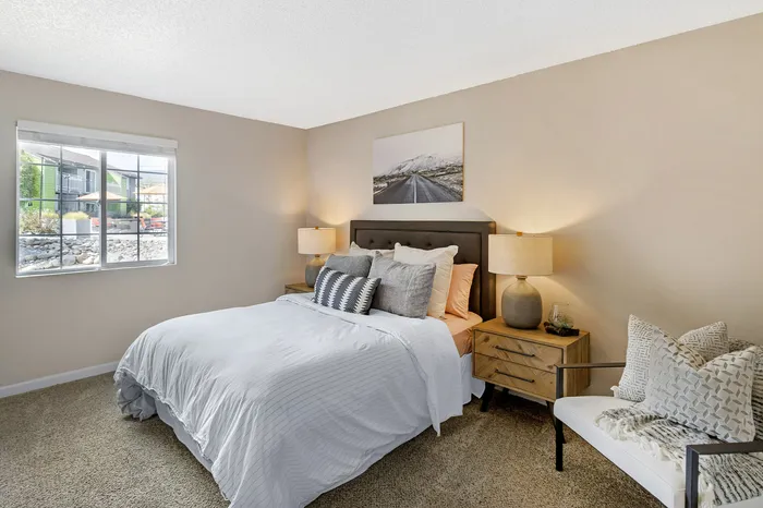 The Phoenix Reno bright bedroom with upholstered bed, stylish side tables, and large window in Reno NV