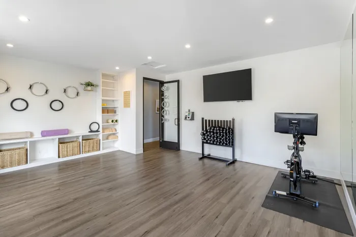 The Phoenix Reno yoga and pilates studio with exercise bike, wall-mounted TV, and yoga prop shelving in Reno NV