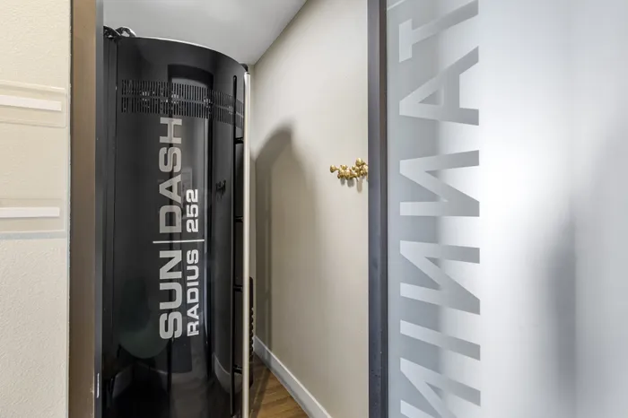 The Phoenix Reno stand-up tanning bed booth with modern Sun Dash unit and minimalist decor in Reno NV