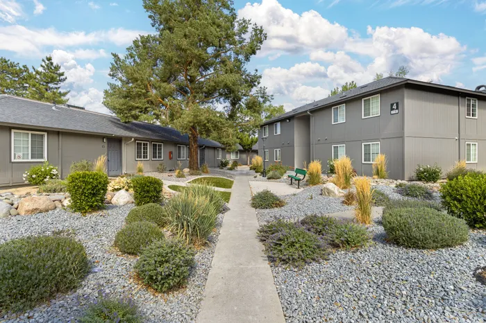 The Phoenix Reno apartment complex exterior with modern design, lush landscaping, and scenic pathways in Reno NV