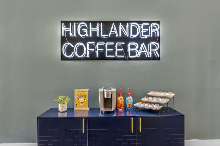 Highlander at North Campus coffee bar with neon sign offering complimentary coffee for residents in Riverside CA