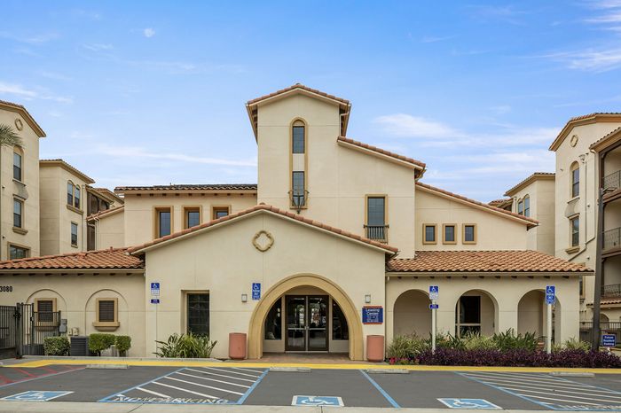Highlander at North Campus leasing office exterior with Mediterranean-style arched entry and terracotta roofing in Riverside CA