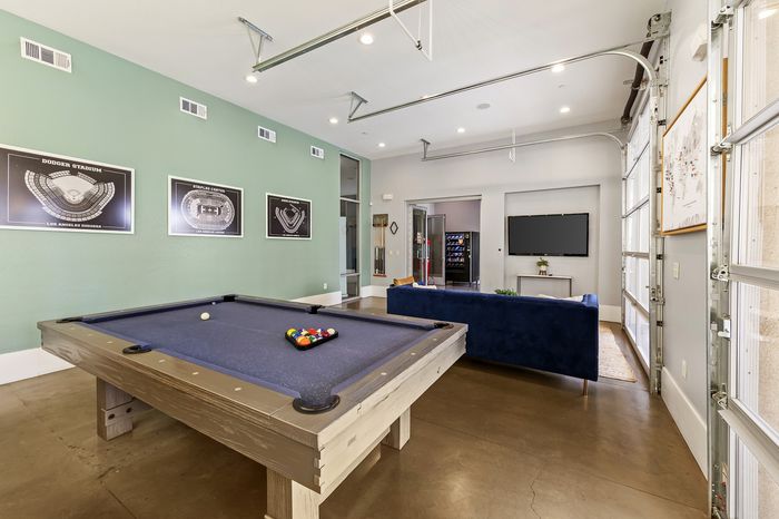 Highlander at North Campus game room with pool table, stylish seating, and vibrant wall art in Riverside CA