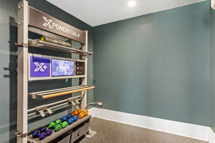 Highlander at North Campus yoga studio workout station with colorful dumbbells and modern teal wall in Riverside CA