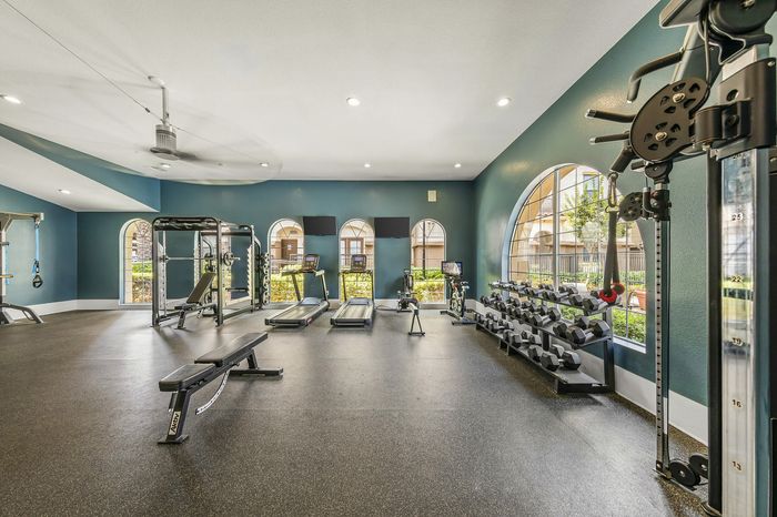 Highlander at North Campus fitness center with state-of-the-art equipment, arched windows, and natural light in Riverside CA