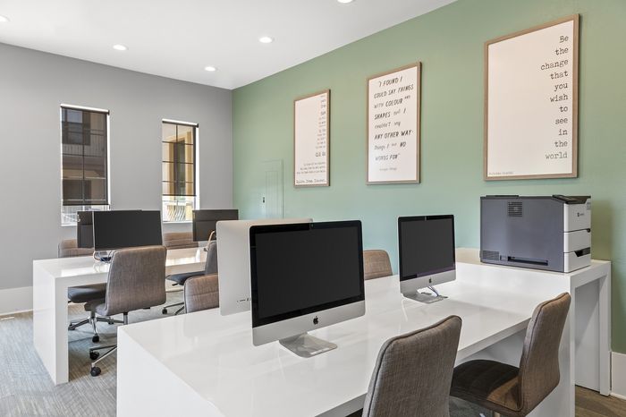 Highlander at North Campus business lounge co-working space with sleek desktops, ergonomic chairs, and inspiring wall art in Riverside CA