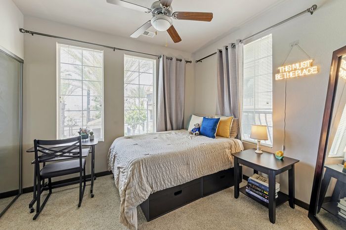 Highlander at North Campus bright cozy bedroom with modern decor, stylish desk, and natural light through large windows in Riverside CA