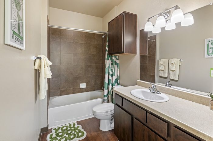 Highlander at North Campus model bathroom with earthy tones, contemporary mirror, and stylish vanity lighting in Riverside CA