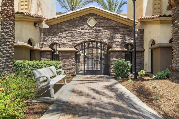 Highlander at North Campus stone facade entryway with lush landscaping and elegant palm trees in Riverside CA