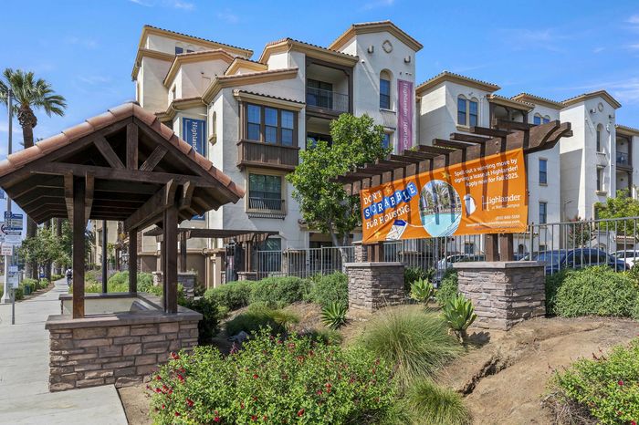 Highlander at North Campus Mediterranean-style exterior with lush landscaping and wooden pergola in Riverside CA