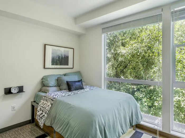 Republic on Main bedroom with modern decor and large window offering lush green views in Moscow, ID