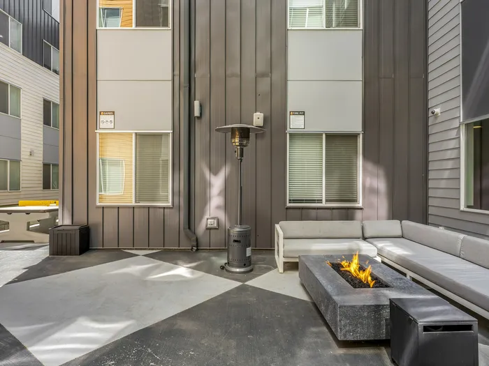 Republic on Main outdoor patio with a cozy gas fire pit, stylish sectional seating, and sleek building facade in Moscow, ID