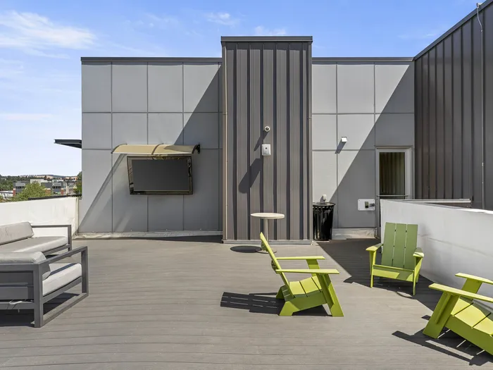 Republic on Main rooftop terrace with modern gray seating and vibrant green chairs, perfect for outdoor relaxation and entertainment under the clear blue sky in Moscow, ID
