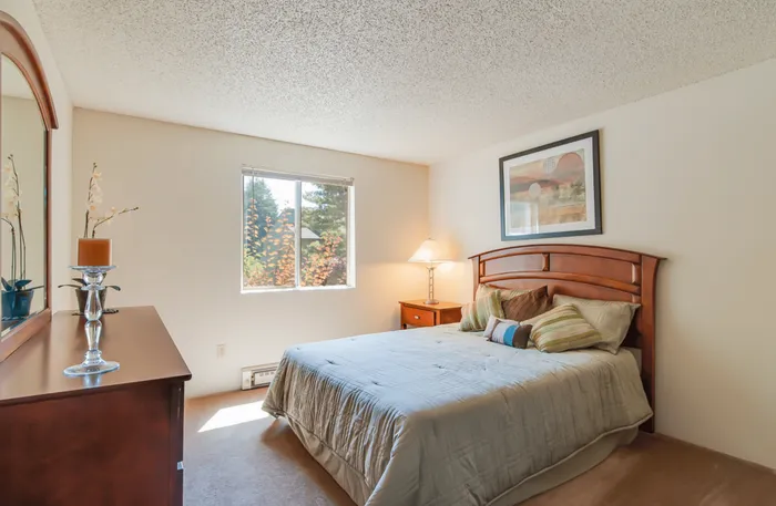 Bright Maplewood Park bedroom with a large window, stylish wooden furniture, and elegant decor creating a cozy atmosphere located in Renton, WA.