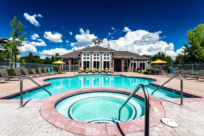 Resort-style pool and spa with sun loungers at Pinnacle Mountain View apartments in Clearfield UT