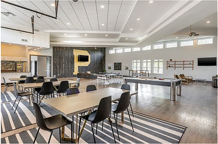 Modern clubhouse with dining area, game tables, and contemporary decor at The Cottages on Lindberg in West Lafayette, IN