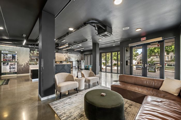 Contemporary open-concept lobby with stylish seating, sleek reception area, and large windows inviting natural light.