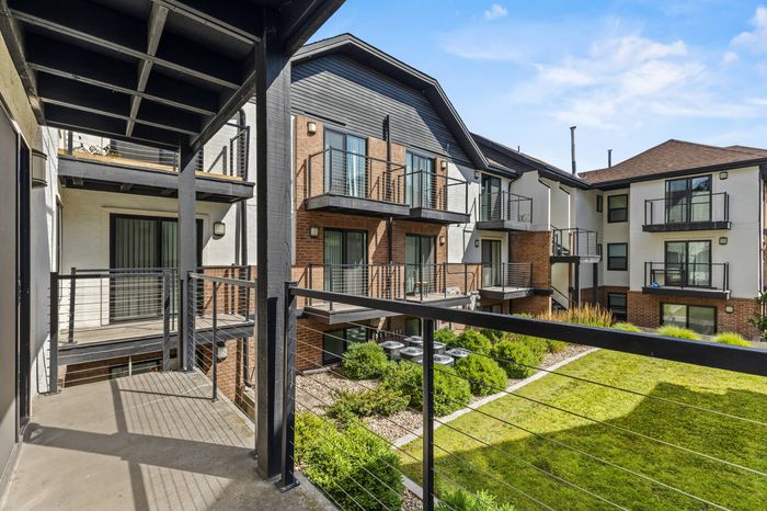 Modern apartment complex with sleek balconies overlooking landscaped greenery, offering a serene and stylish living environment.