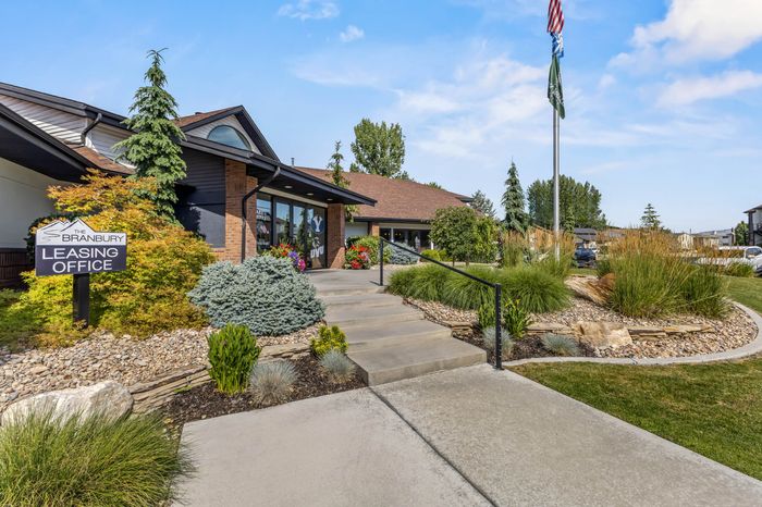 Inviting leasing office entrance with lush landscaping and modern architecture.
