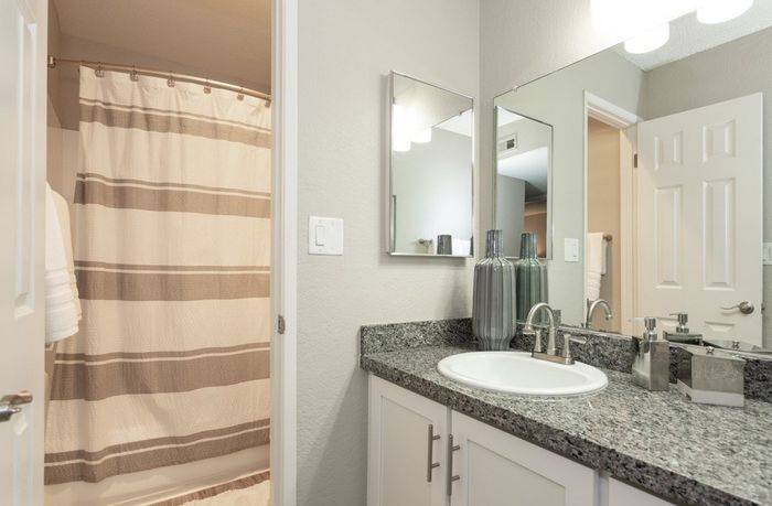 Elegant bathroom with granite countertop, stylish fixtures, and cozy ambiance.
