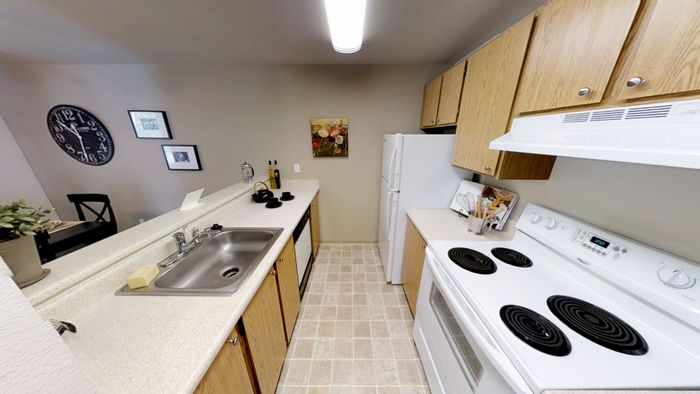 Inviting kitchen with modern appliances, sleek countertops, and warm wooden cabinetry, perfect for culinary creativity.