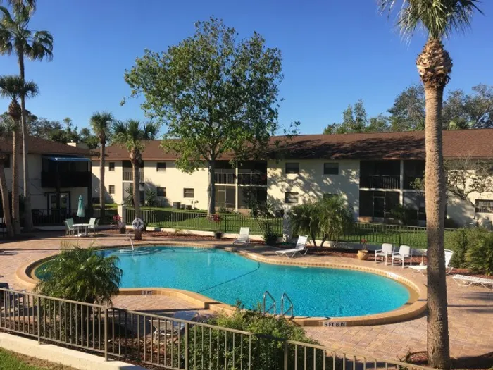 Marcell Gardens Apartments, exterior, sparkling blue swimming pool, two story building, balconies,