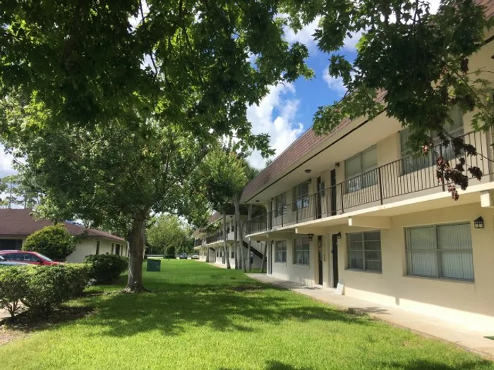Marcell Gardens Apartments, exterior, 2 story building, grass, trees, cars,