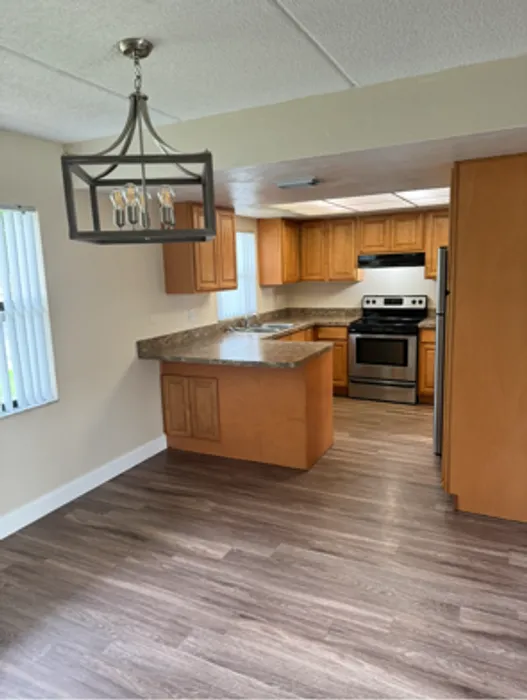 Marcell Gardens Apartments, interior, kitchen, peninsula counter, stainless steel appliances, open to front room, tile and carpet