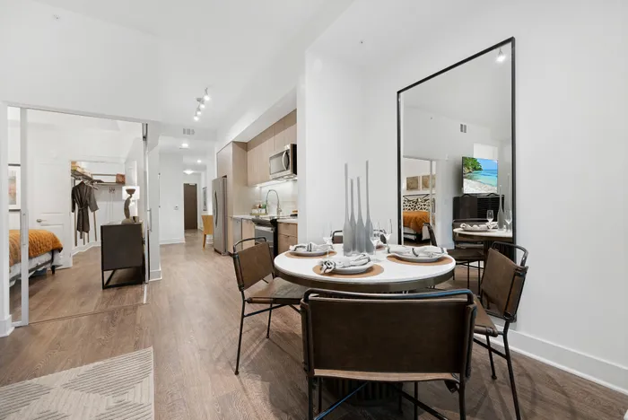 Spacious studio apartment dining area with four chairs.