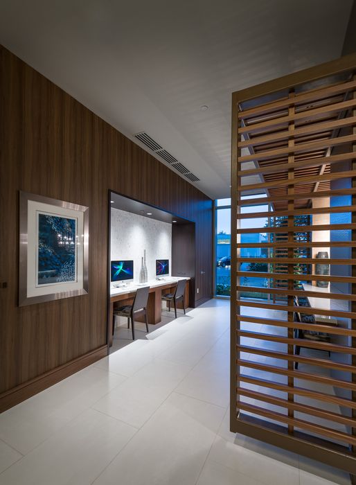 E-lounge with built-in desks furnished with iMac computers, wood-paneled walls, and floor-to-ceiling windows