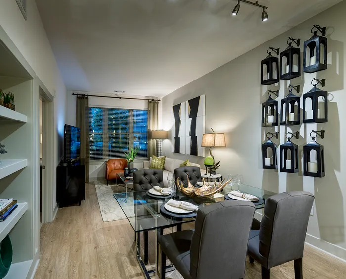 A living and dining room with light wood-style flooring, built-in shelves and contemporary furnishings.
