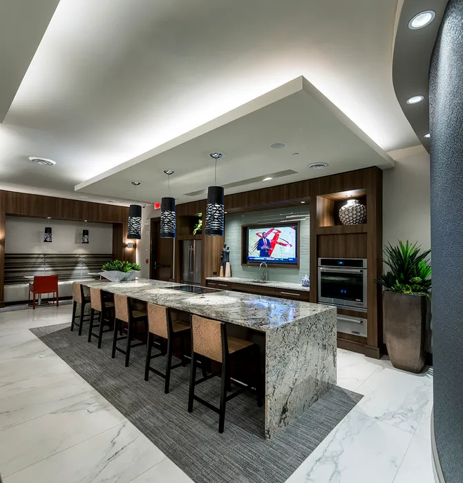 Resident pantry with a 5-seat breakfast bar, banquet seating, stainless steel appliances, and a flat-screen TV.