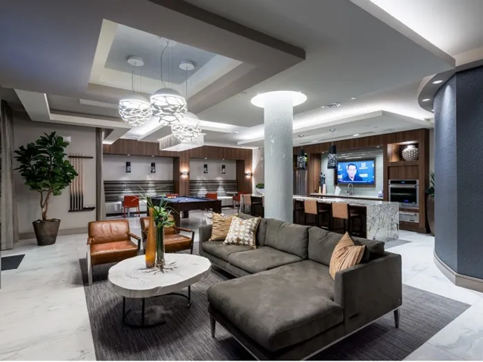 Billiards lounge with seating area and a wet bar with stainless steel kitchen appliances.